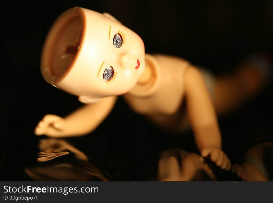 Close up of a doll with missing parts with a black background and shallow DOF. Close up of a doll with missing parts with a black background and shallow DOF