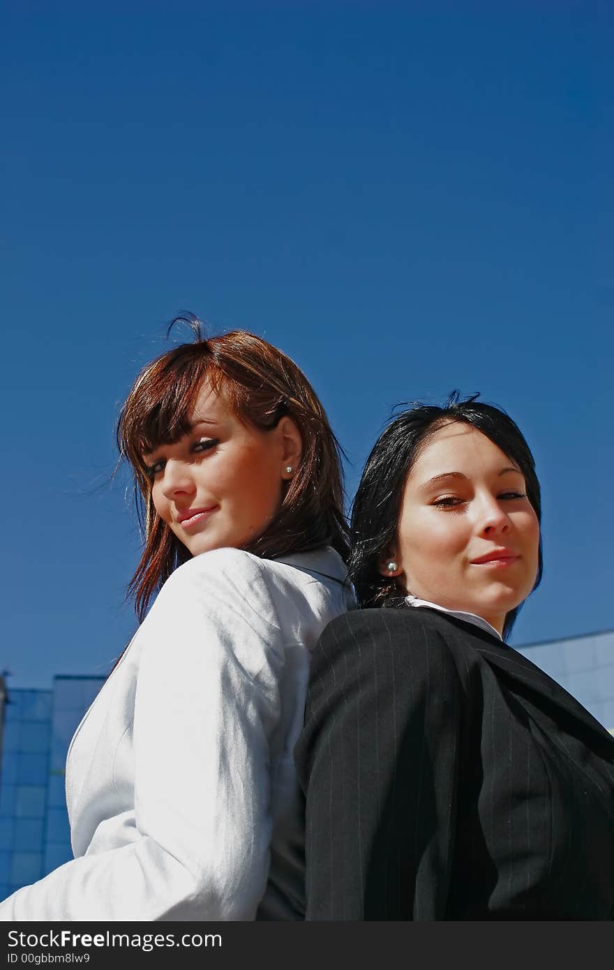 Portrait of two young women opposed back-to-back. Portrait of two young women opposed back-to-back