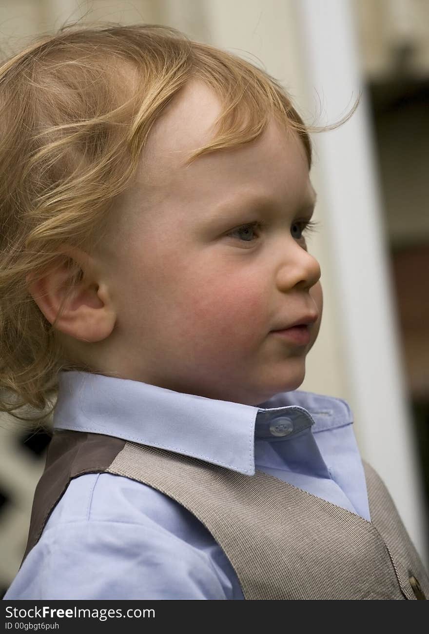 A dressed up boy outside deep in thought. A dressed up boy outside deep in thought