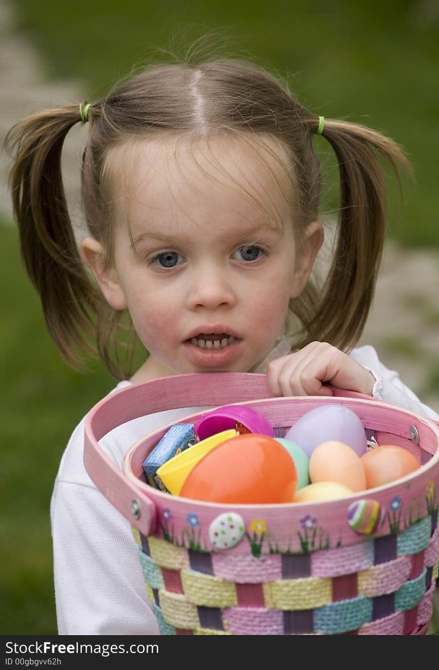 A young girl hugging a basket full of Easter eggs. A young girl hugging a basket full of Easter eggs