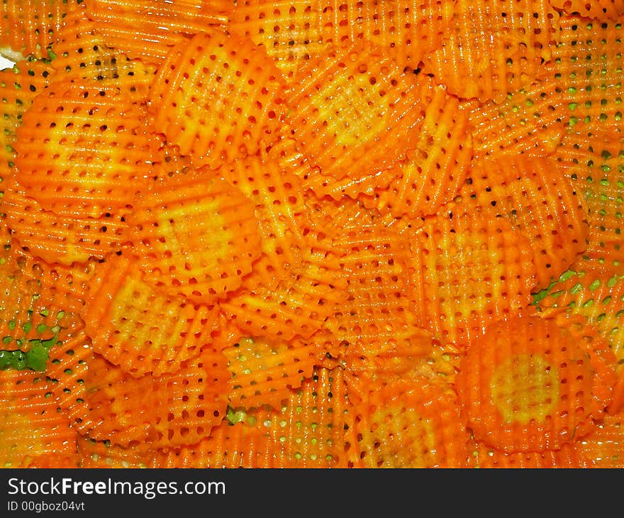 Slices of decorative carrots as prepared for garnishing salad. Slices of decorative carrots as prepared for garnishing salad.