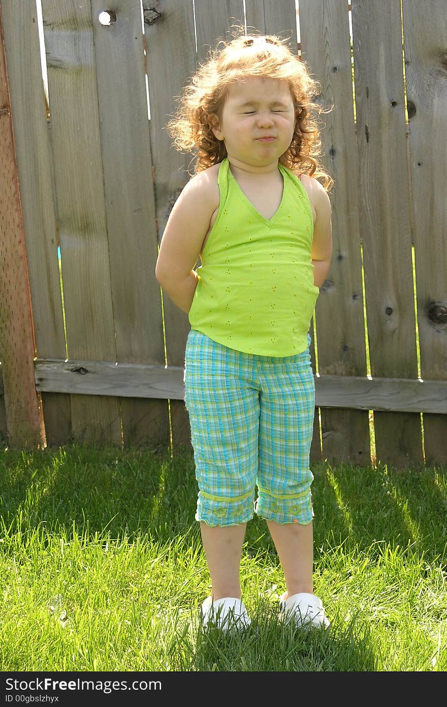 Little red haired girl in green with sour look on face. Little red haired girl in green with sour look on face.