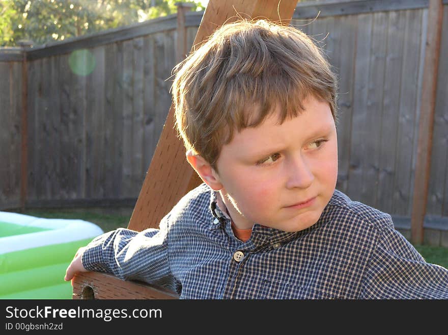 Young boy looking off in the distance with a suspicious look on his face. Young boy looking off in the distance with a suspicious look on his face.