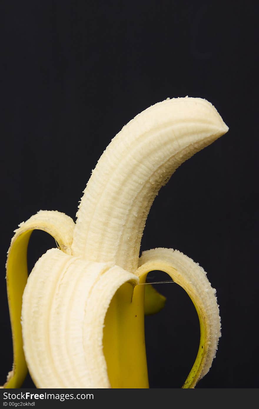 Peeled banana isolated on black