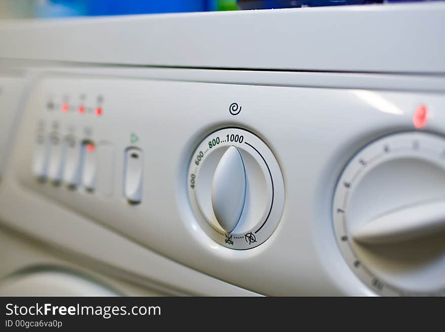 Close-up panel white washing machine. Low DOF. Focus on rotary switch to set the rotational speed. Close-up panel white washing machine. Low DOF. Focus on rotary switch to set the rotational speed.