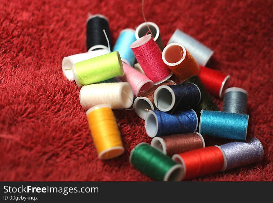 Rows of Different Colored Spools of Thread on Red Towel. Rows of Different Colored Spools of Thread on Red Towel