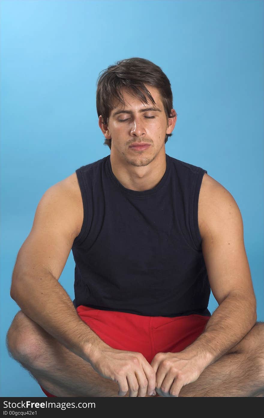 Man in black shirt exercising over blue background. Man in black shirt exercising over blue background