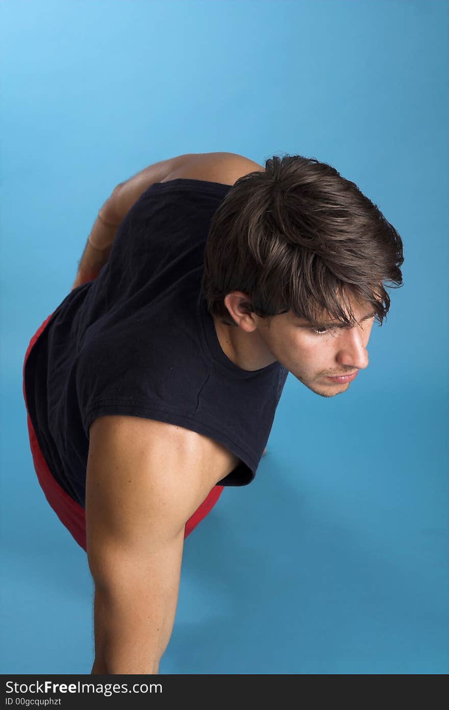 Man in black shirt exercising over blue background. Man in black shirt exercising over blue background