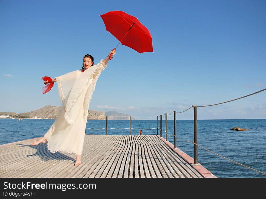 Girl with red umbrella on the wharf