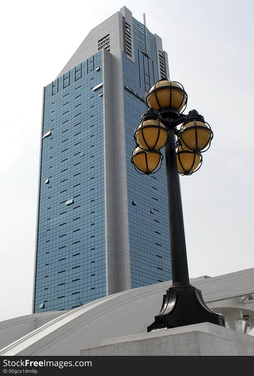 A modern business building is contrasted against a victorian era lamppost. A modern business building is contrasted against a victorian era lamppost