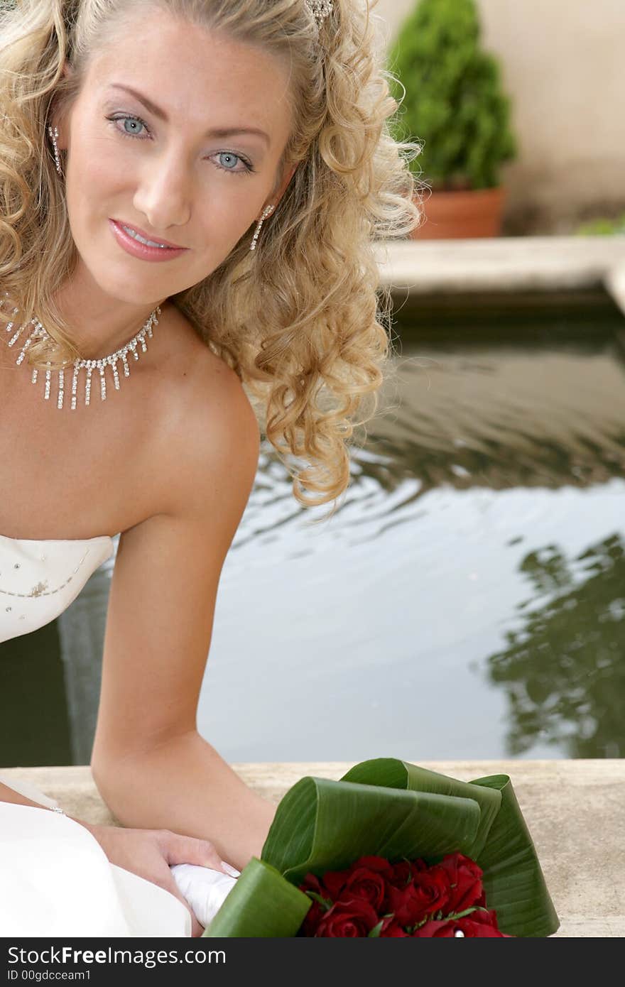 A bride on her wedding day next to a little pond. A bride on her wedding day next to a little pond