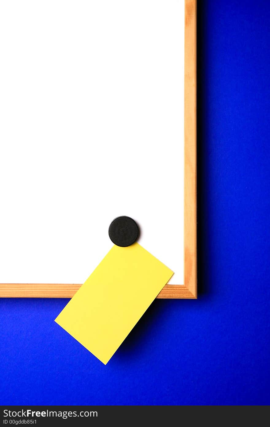 Whiteboard with empty yellow post-it note and magnet in the form of a hart. Whiteboard with empty yellow post-it note and magnet in the form of a hart