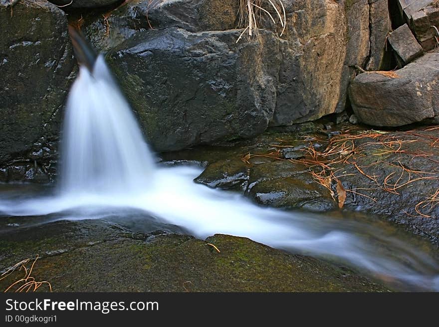 A small waterfall following a path. A small waterfall following a path