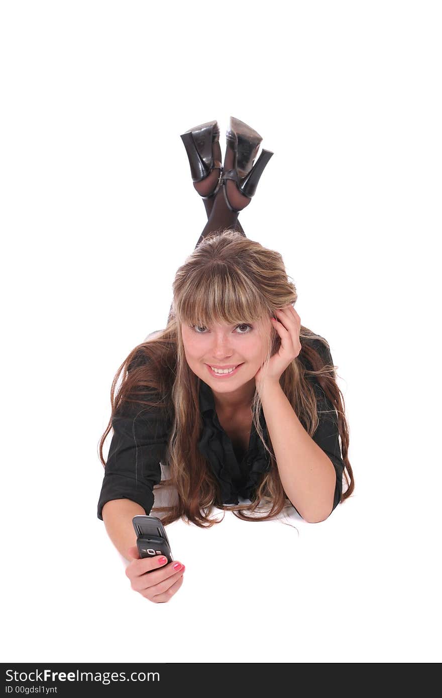 A smiling woman laying with a phone in her hand on white background. A smiling woman laying with a phone in her hand on white background