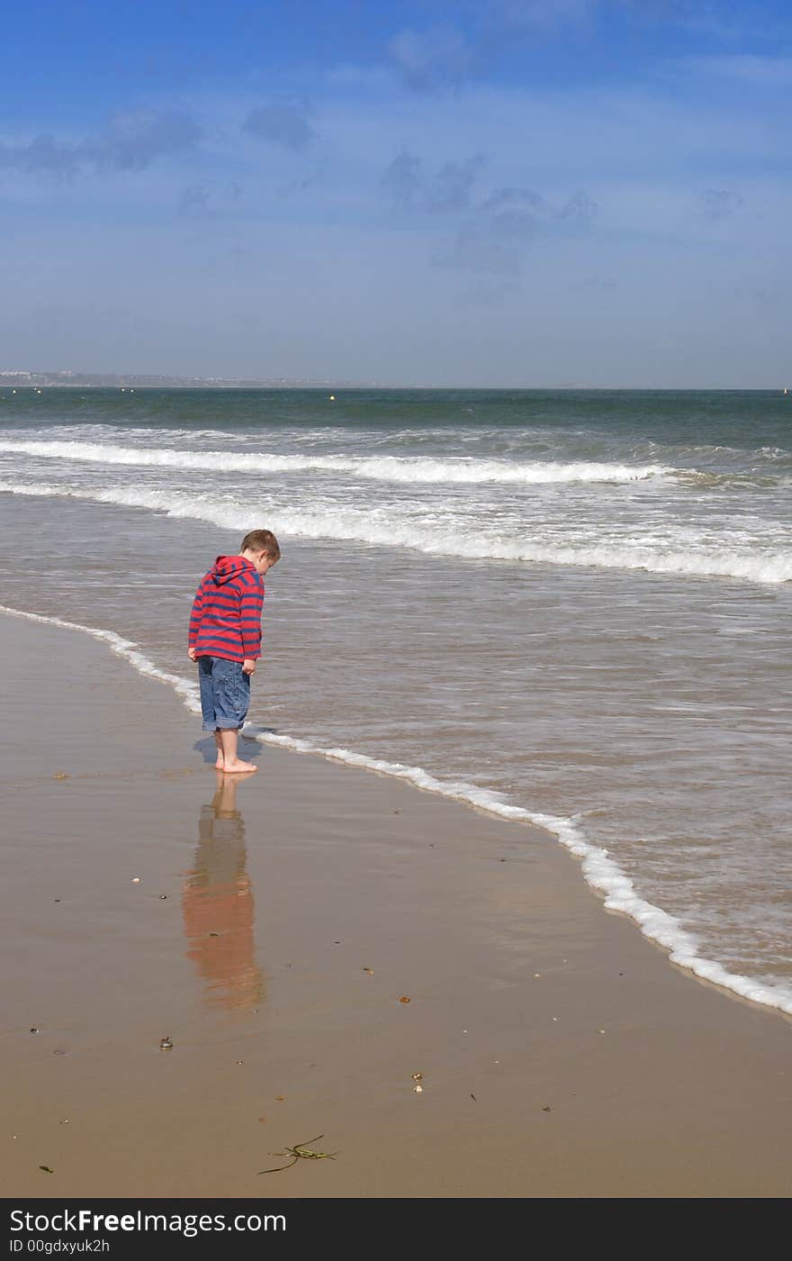 Little boy on a beach and reflection