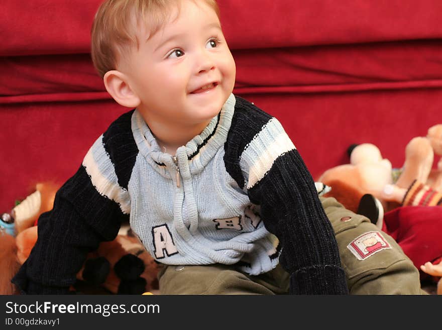 Little blond baby boy playing with toys at home