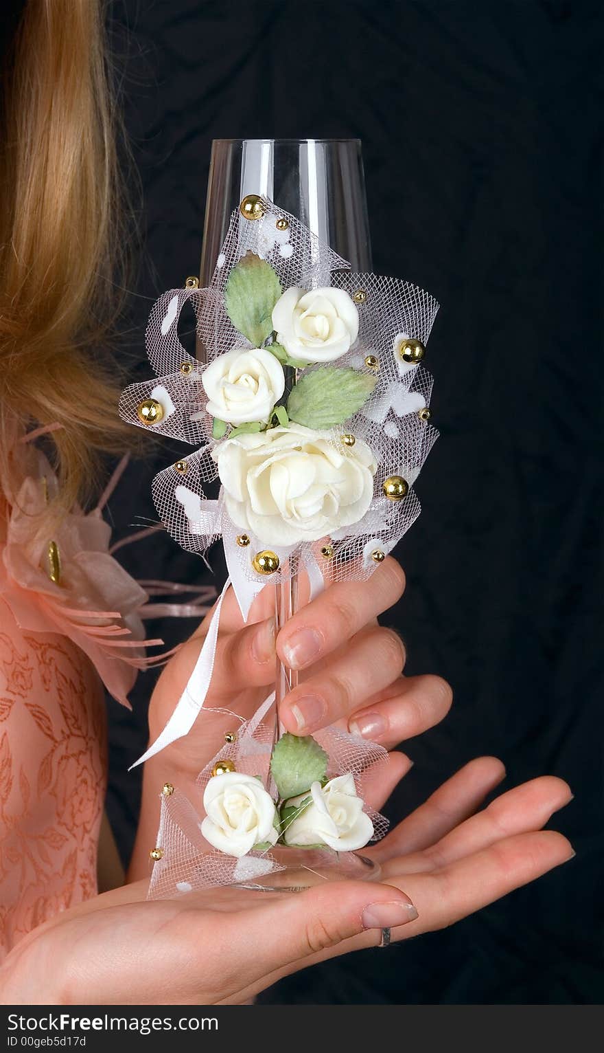 Wedding glass in hands of the bride on a black background