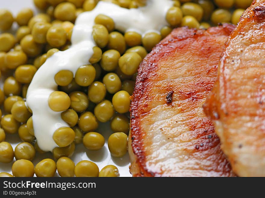 Fried pork and green peas with sauce close-up