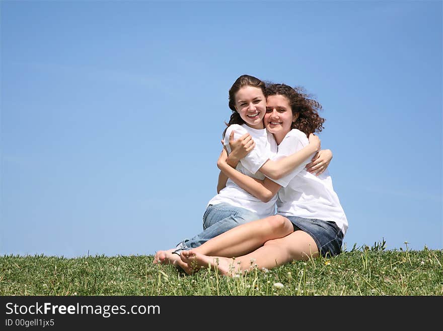 Two girlfriends in white T-shorts embrace