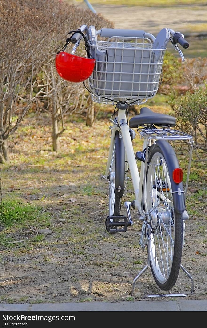 Image of a bicycle with a kid helmet hanging down in a park. Image of a bicycle with a kid helmet hanging down in a park.