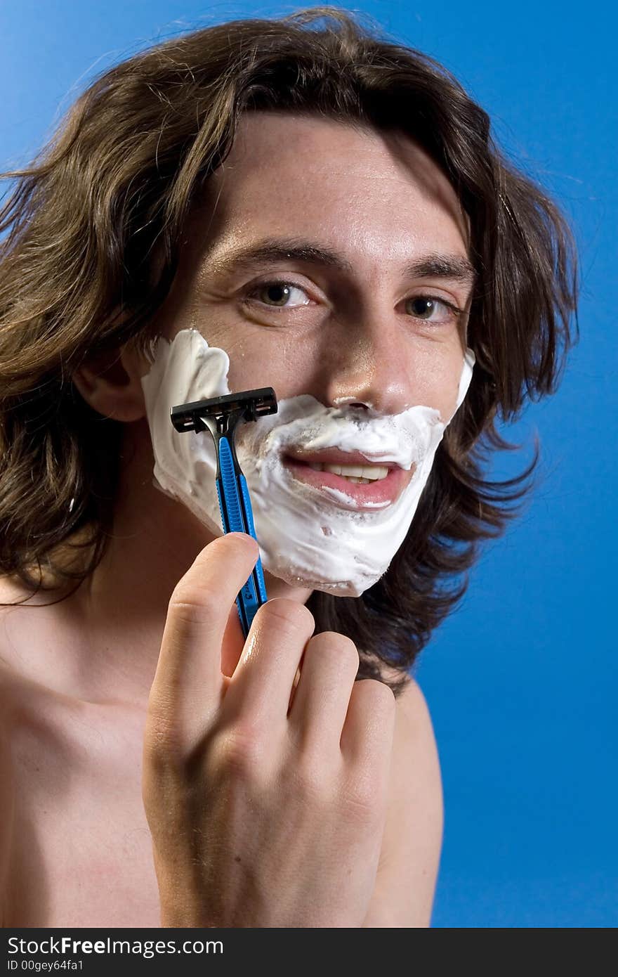 Young male taking a shave. Young male taking a shave