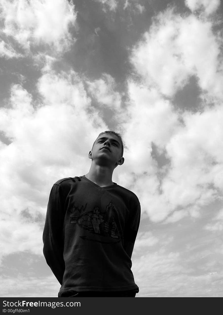 The boy stands on a sky background. The boy stands on a sky background