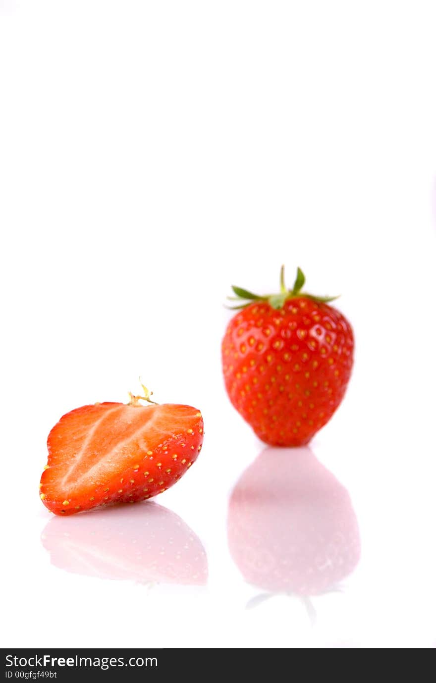 Full and half strawberry isolated over white with reflection. Full and half strawberry isolated over white with reflection