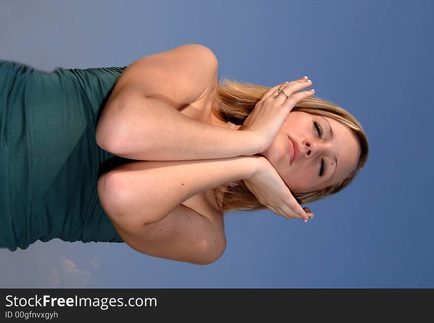 A pretty teen girl with eyes closed and hands cupping her face. A pretty teen girl with eyes closed and hands cupping her face