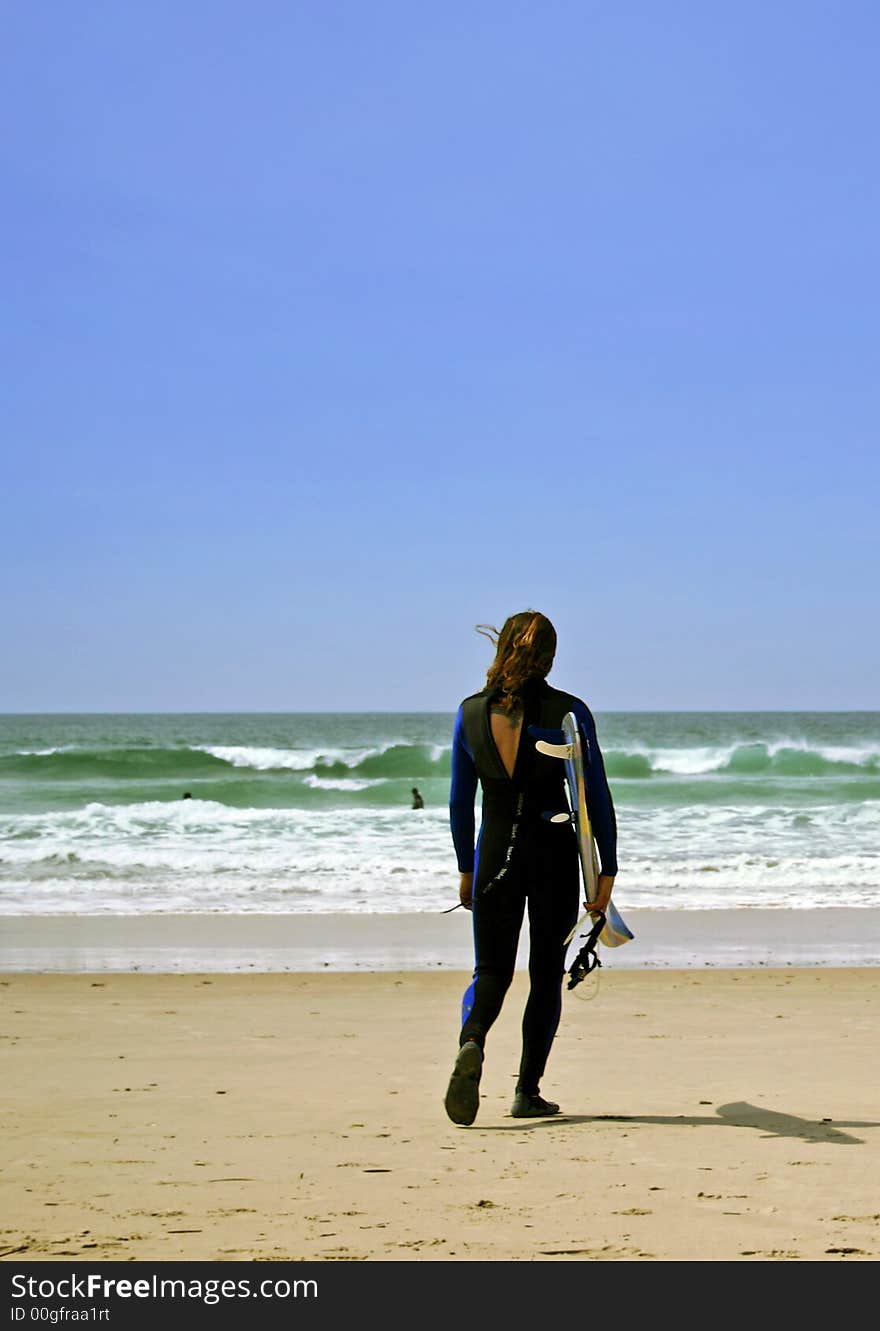 A photo of a surfer going to the water. A photo of a surfer going to the water.