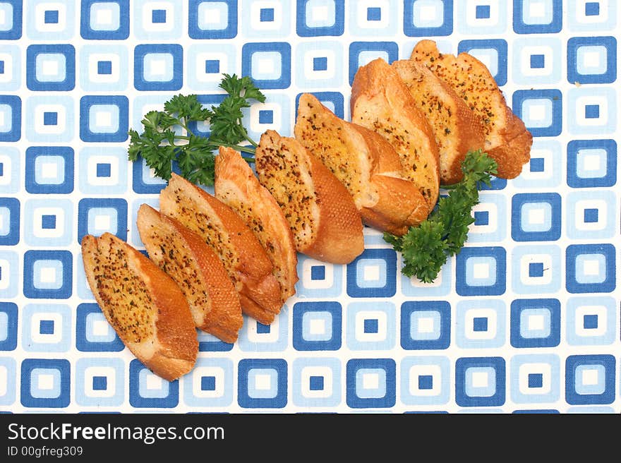 Garlic bread slices laid on a retro blue squared table-mat