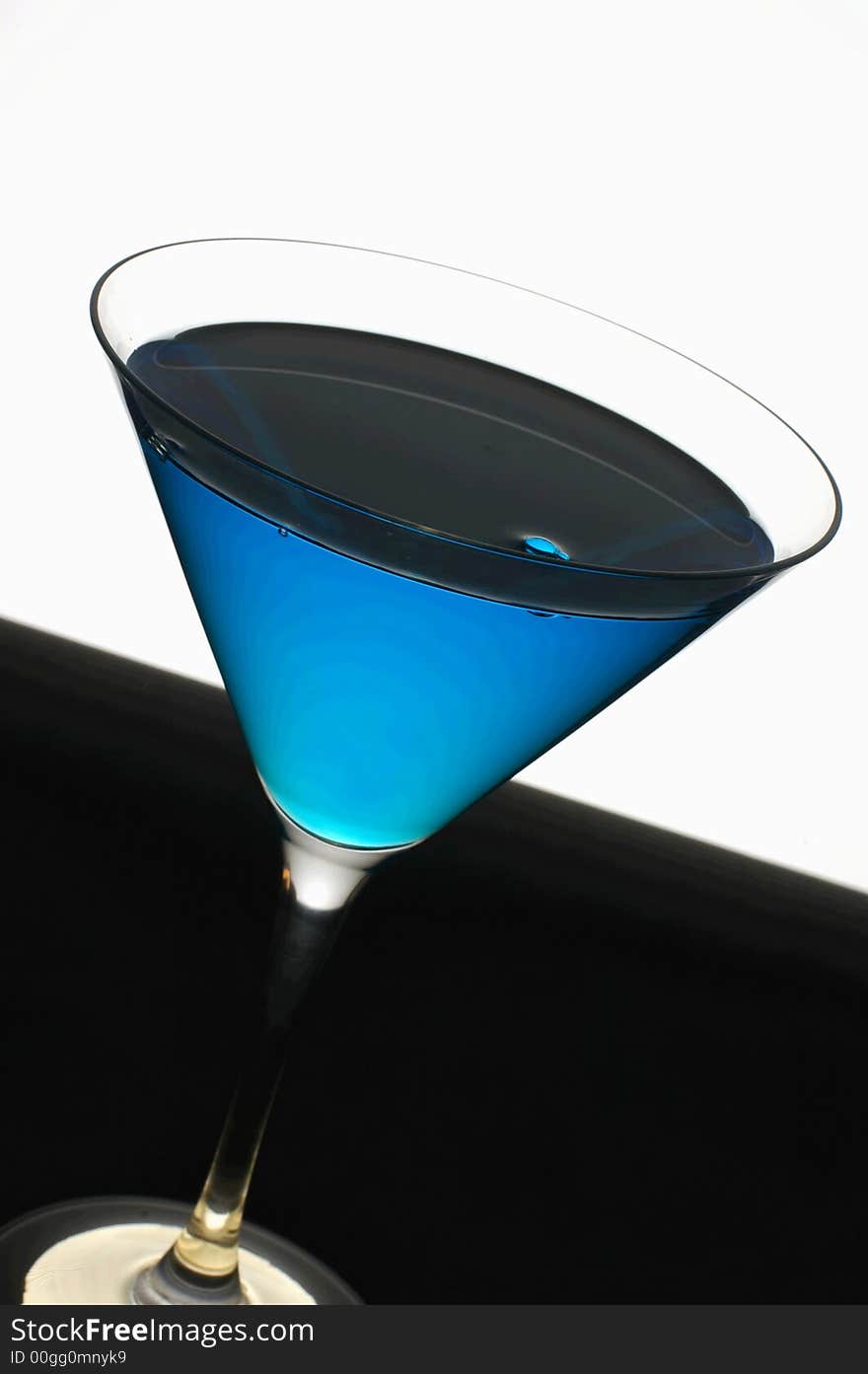 Simple but stylish mint blue cocktail against a white and black background. Simple but stylish mint blue cocktail against a white and black background.