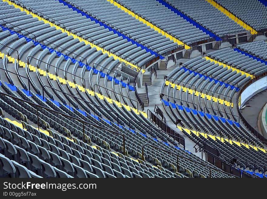 A field of empty grey plastic stadium seats.