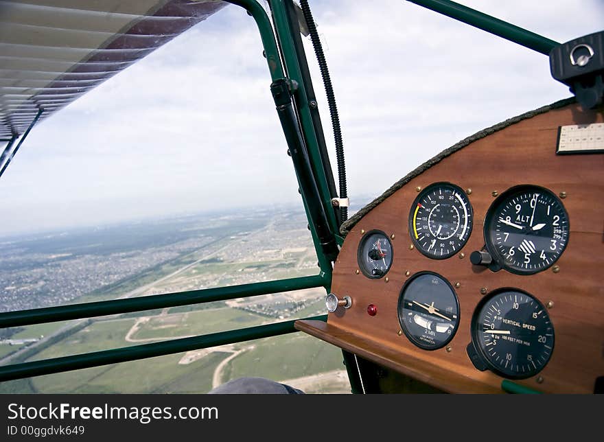 View of the city from the window of a small single engine airplane with the focus on the instrument panel. View of the city from the window of a small single engine airplane with the focus on the instrument panel.