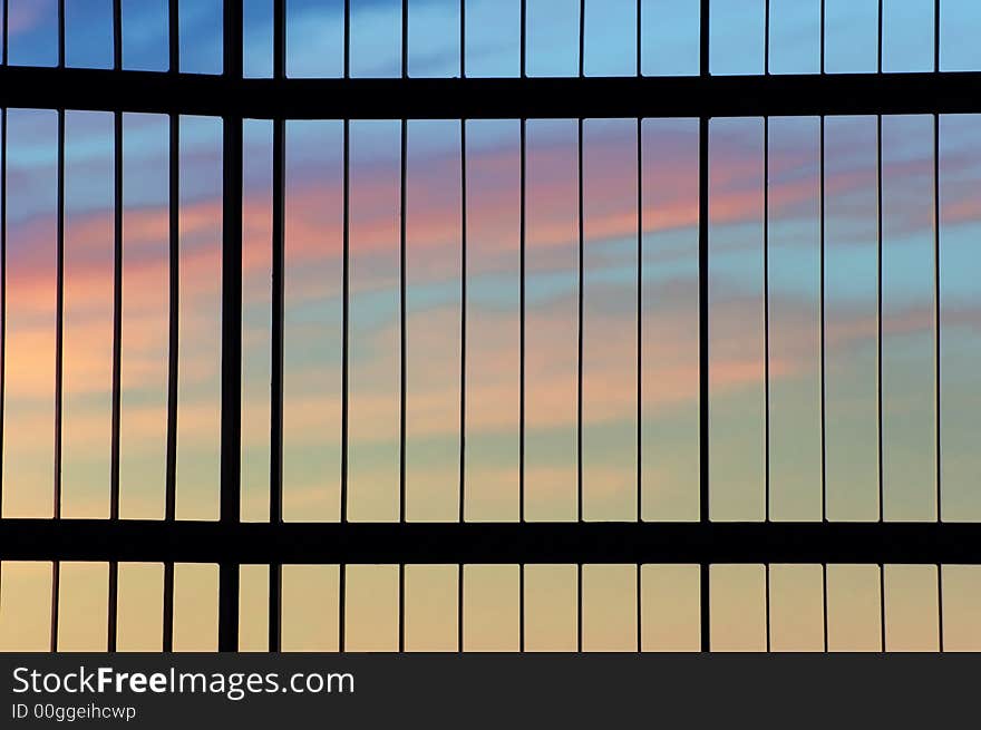 A colourful sunset seen through a gate. A colourful sunset seen through a gate