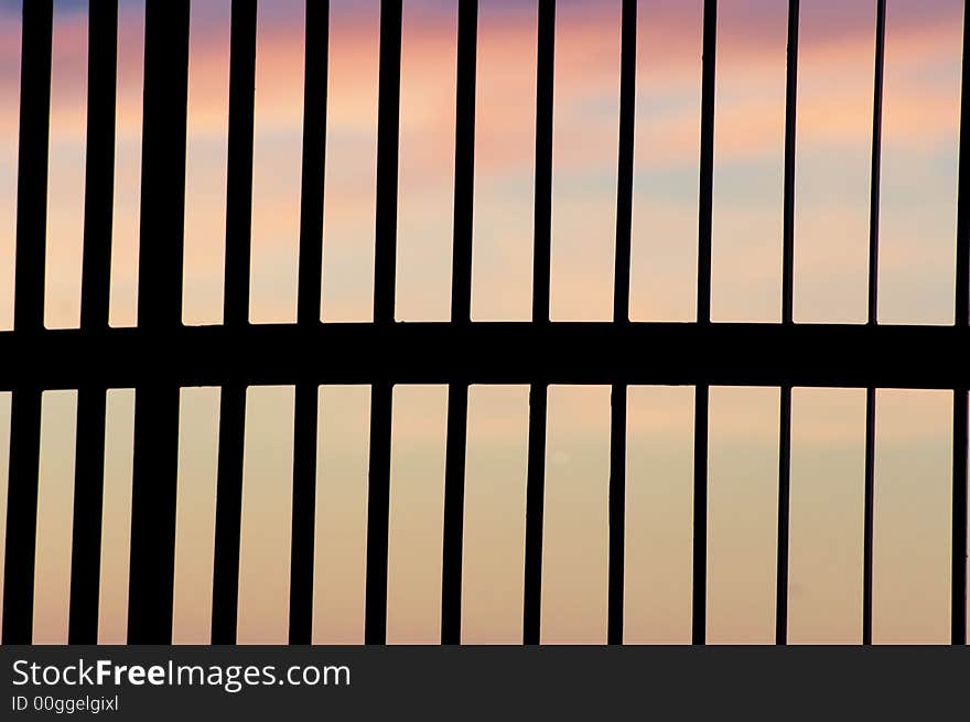 A colourful sunset seen through a gate. A colourful sunset seen through a gate