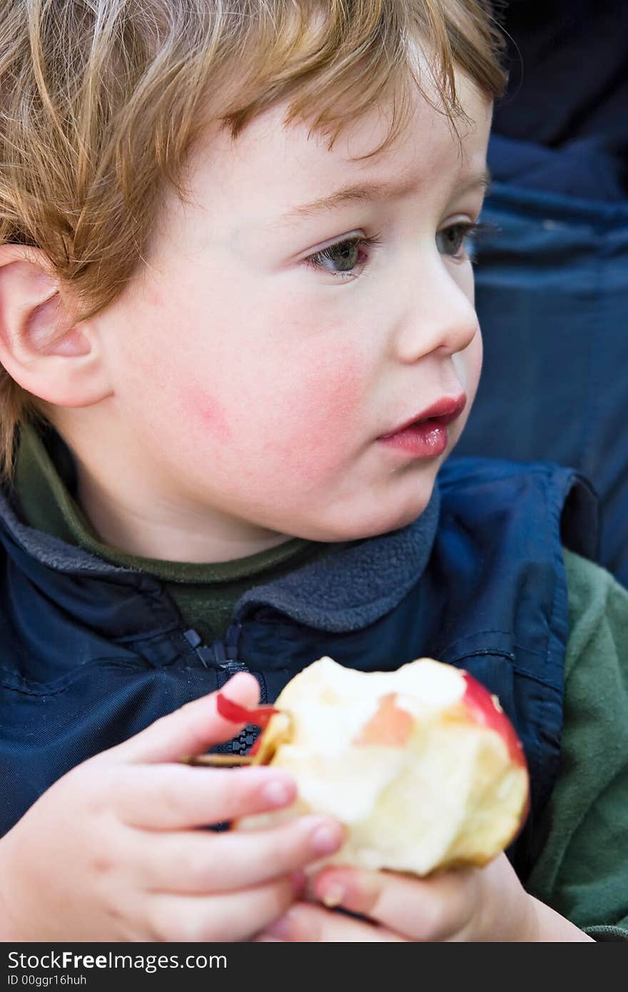 Boy eats an apple and has fun on walk