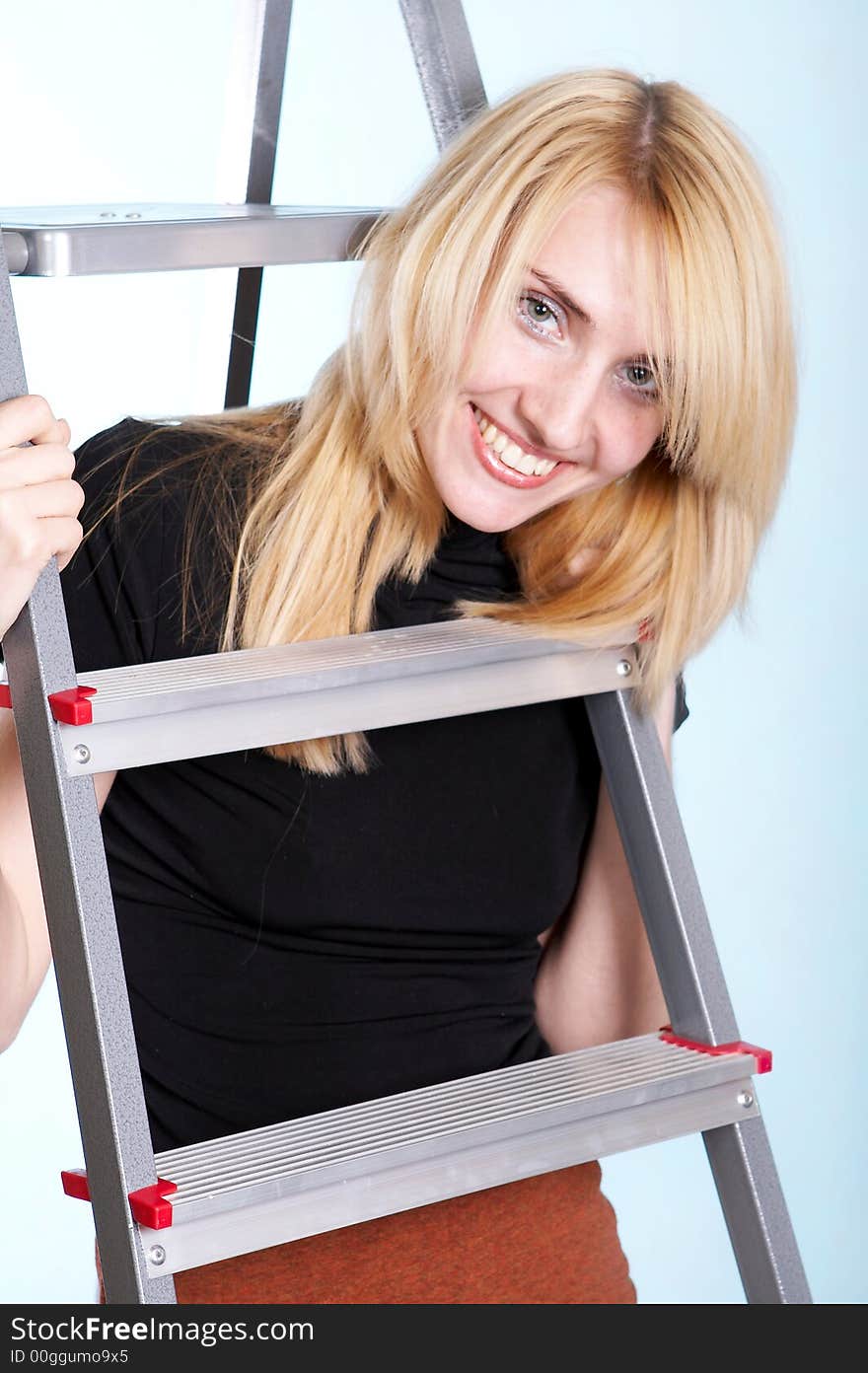 Woman in a short skirt standing under ladder. Woman in a short skirt standing under ladder