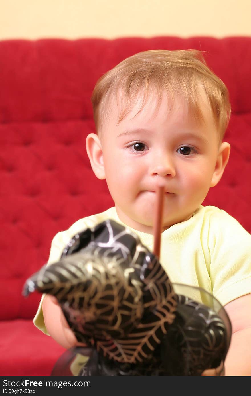 Little blond baby boy gesticulate while playing with wizard doll at home