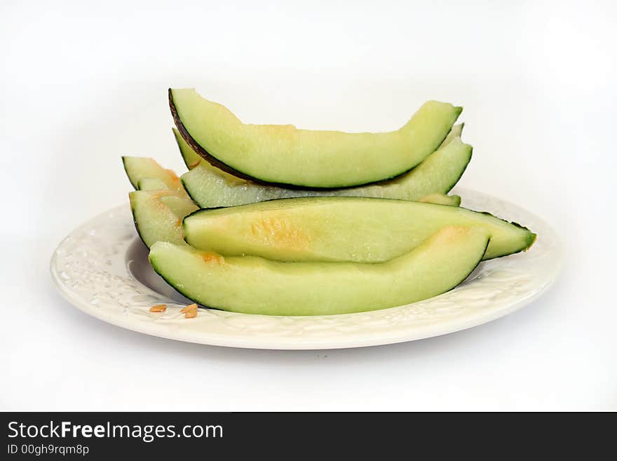 A plate of cut up mellon isolated on a white background. A plate of cut up mellon isolated on a white background.