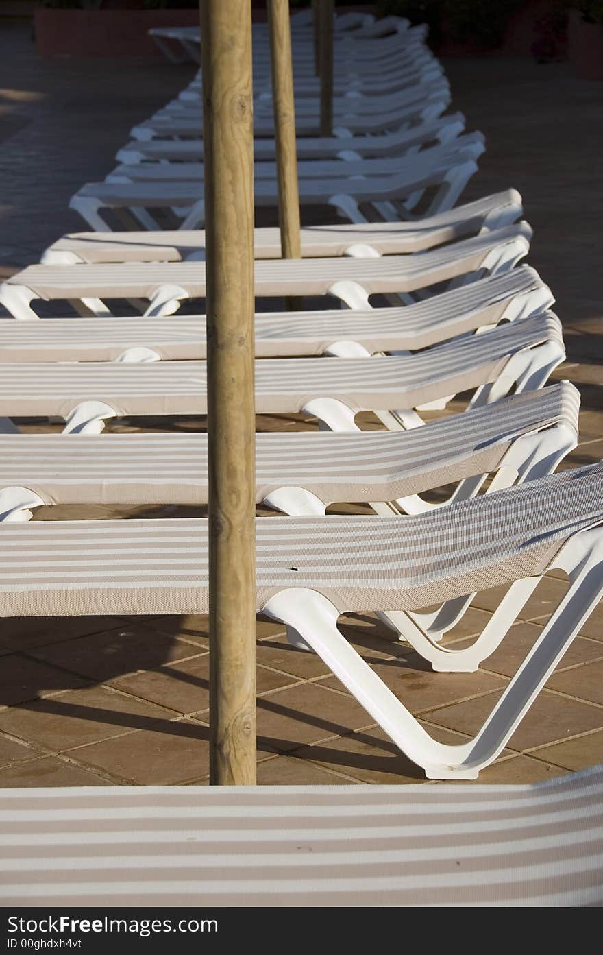 Beige and white sun loungers sat in the sun