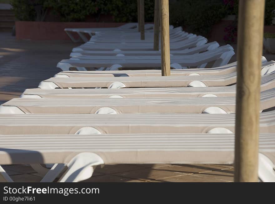 Beige and white sun loungers sat in the sun