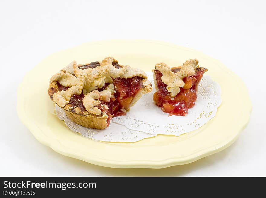 An individual cherry peach pie with lattice crust sliced and plated.