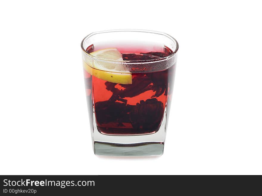 Glass of bright-red hot hibiscus tea. Isolated on white background.