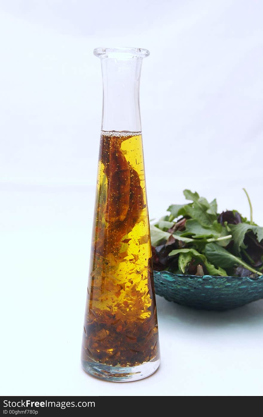 Oil bottle and healthy salad in  a white background. Oil bottle and healthy salad in  a white background