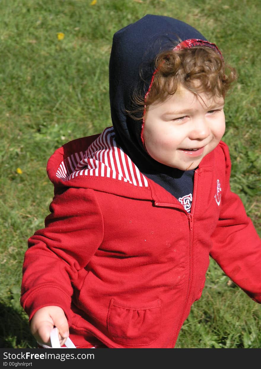 Little redheaded curly top girl in red looking very pleased with herself!. Little redheaded curly top girl in red looking very pleased with herself!