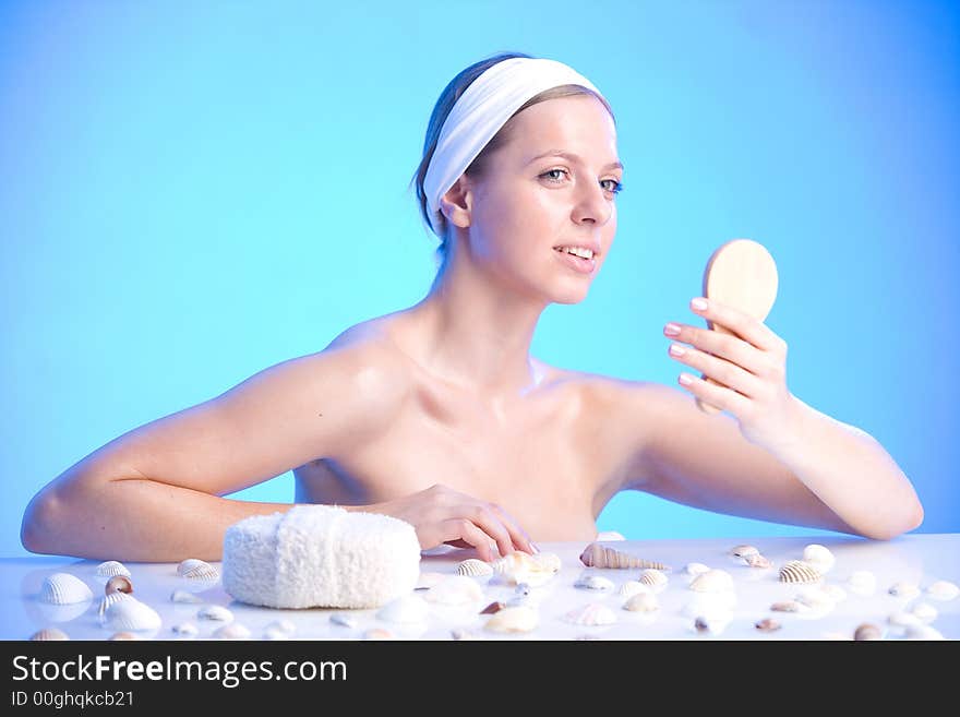 Young beautiful smiling woman with a bath sponge and a small mirror. Young beautiful smiling woman with a bath sponge and a small mirror