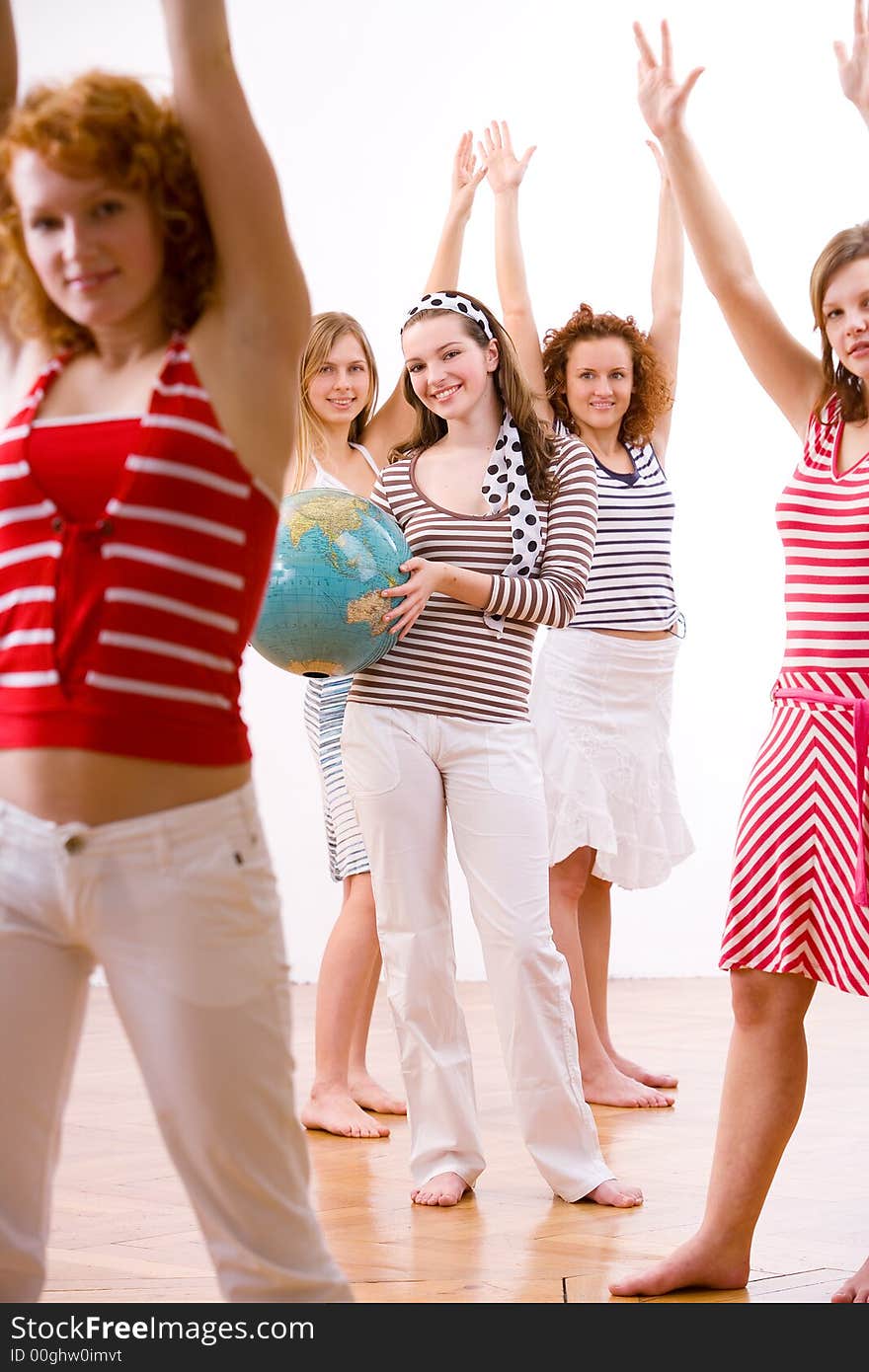 Five attractive young girls in summerclothes jubilating holding a globe. Five attractive young girls in summerclothes jubilating holding a globe