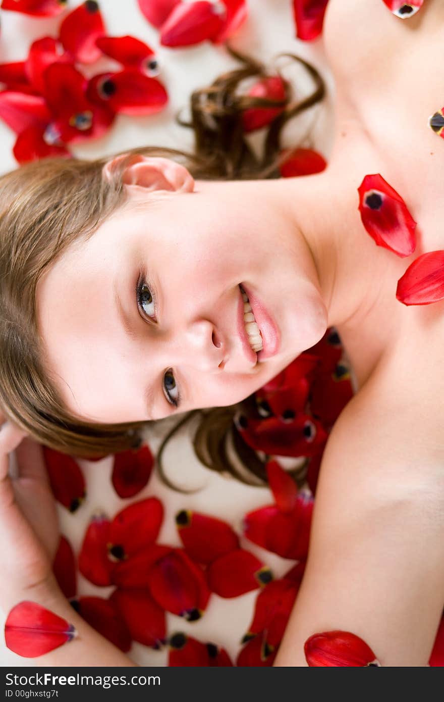 A young woman laying on tulip petals. A young woman laying on tulip petals