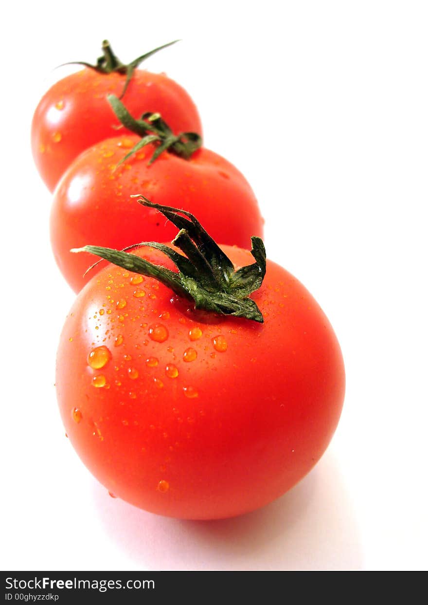 Three tomatos over white