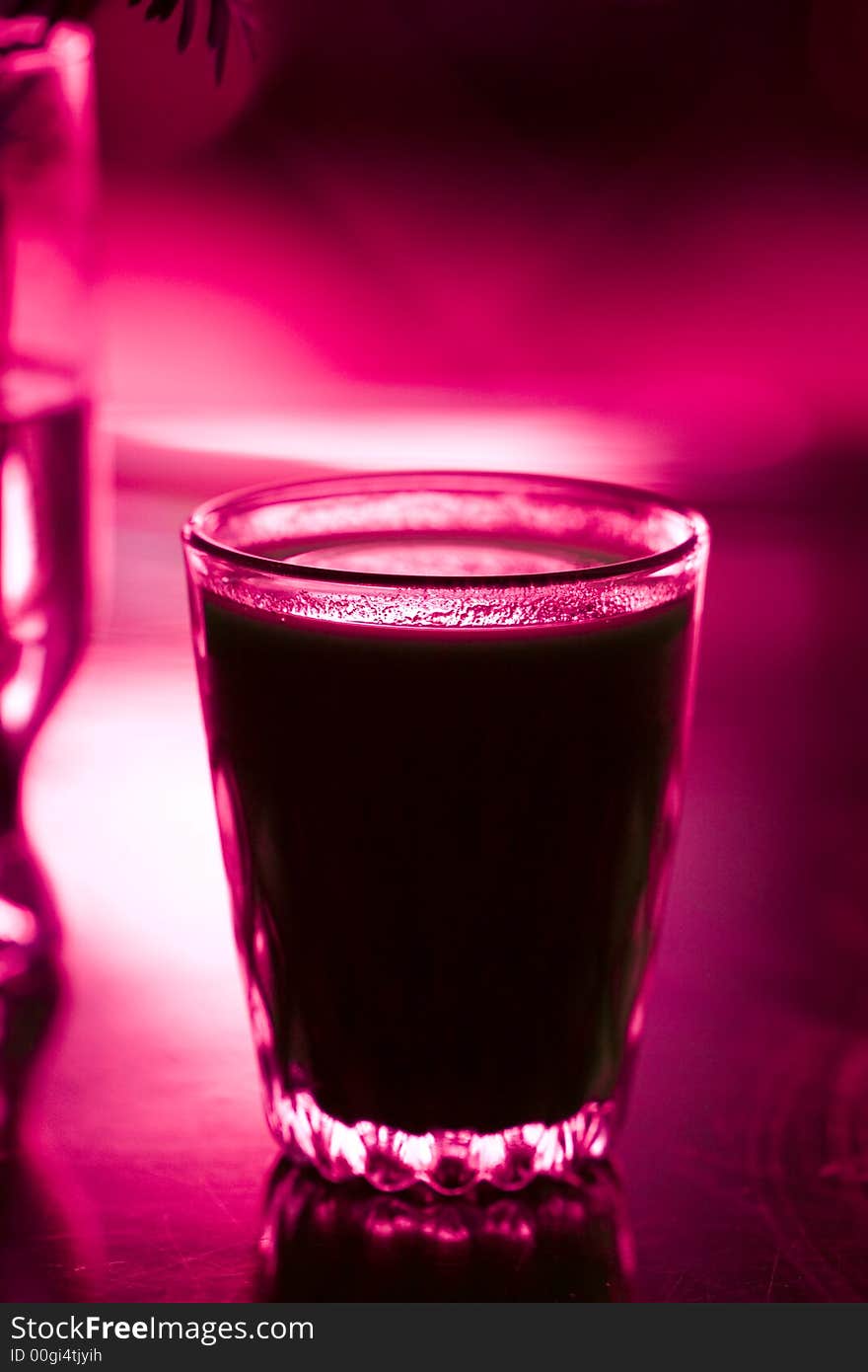 Glass with beverage on red color. Glass with beverage on red color